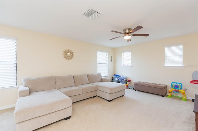 living room featuring carpet flooring, ceiling fan, visible vents, and baseboards