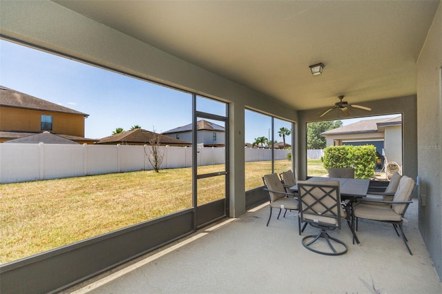 sunroom / solarium with a ceiling fan and outdoor dining space