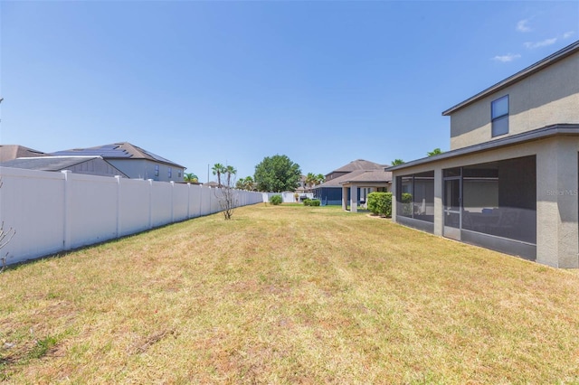view of yard featuring fence and a sunroom