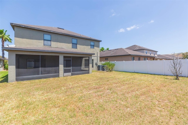 back of property featuring central AC, fence, stucco siding, a sunroom, and a yard