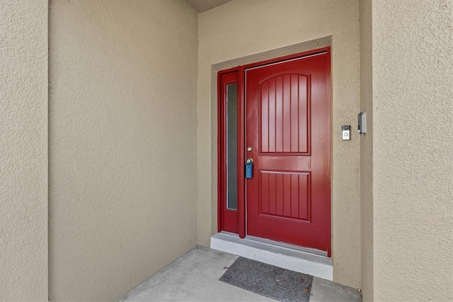entrance to property featuring stucco siding