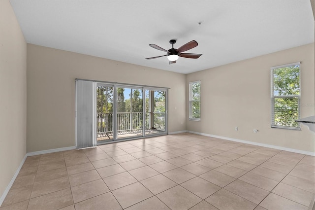 spare room featuring ceiling fan, baseboards, and light tile patterned floors