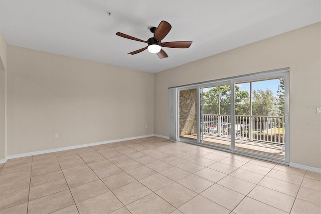 empty room featuring a ceiling fan, baseboards, and light tile patterned floors