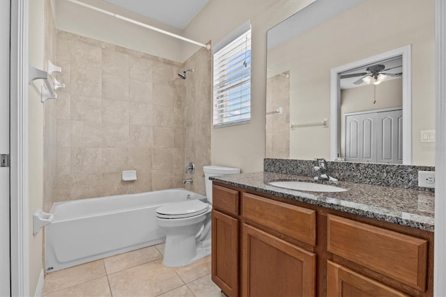 bathroom with a ceiling fan, tile patterned flooring, toilet, vanity, and washtub / shower combination