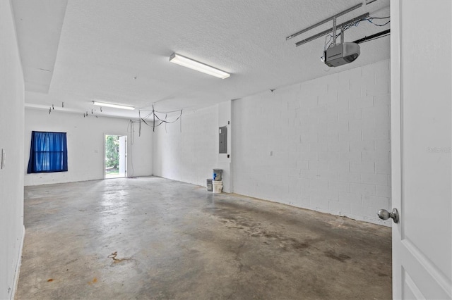 garage with a garage door opener, electric panel, and concrete block wall