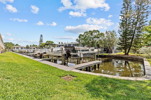 dock area featuring boat lift, a yard, and a water view