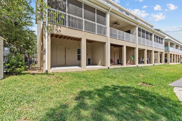 back of property with ceiling fan, a patio, a lawn, and stucco siding