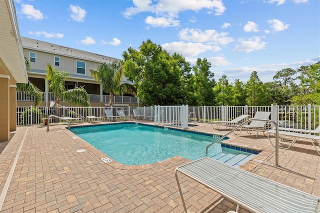 community pool featuring a patio and fence