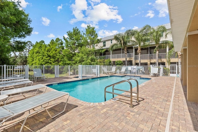 community pool featuring fence and a patio