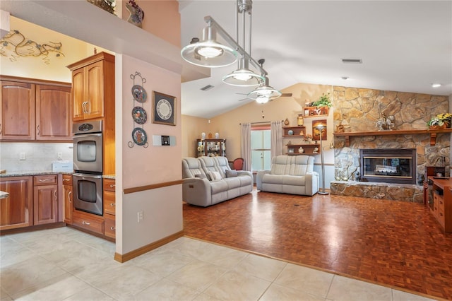 7353 Dogwood Cres, Spring Hill, FL 34607 - living room featuring ceiling fan, vaulted ceiling, a stone fireplace, and baseboards