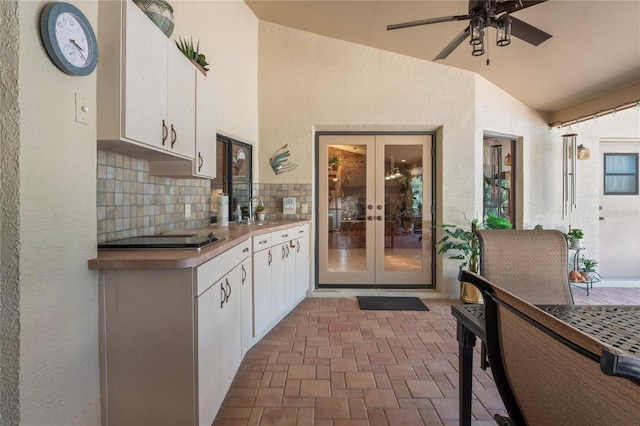 7353 Dogwood Cres, Spring Hill, FL 34607 - kitchen featuring black electric cooktop, french doors, vaulted ceiling, white cabinets, and a sink