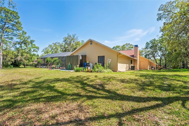 7353 Dogwood Cres, Spring Hill, FL 34607 - back of property with a chimney, stucco siding, a lawn, and central AC