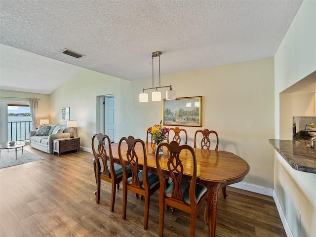 dining space with visible vents, baseboards, dark wood finished floors, and vaulted ceiling