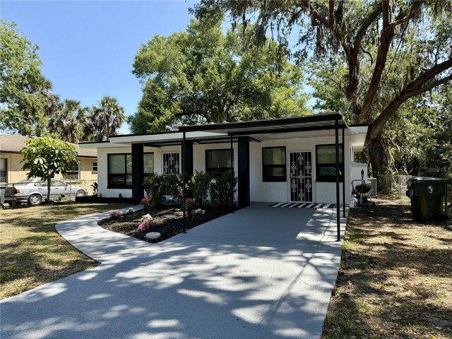 635 Mccormick St, Daytona Beach, FL 32114 - view of front of home with fence, a carport, stucco siding, and driveway