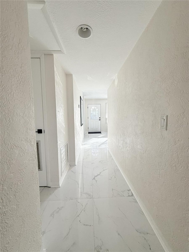 635 Mccormick St, Daytona Beach, FL 32114 - hallway featuring a textured ceiling, a textured wall, baseboards, and marble finish floor