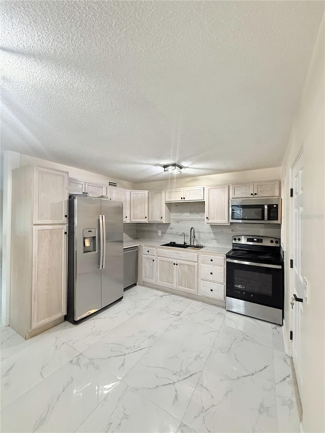 635 Mccormick St, Daytona Beach, FL 32114 - kitchen featuring stainless steel appliances, a textured ceiling, a sink, and light brown cabinets
