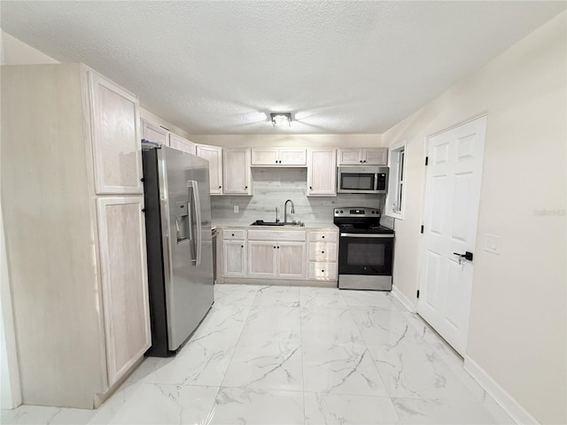 635 Mccormick St, Daytona Beach, FL 32114 - kitchen with a textured ceiling, appliances with stainless steel finishes, a sink, light countertops, and marble finish floor