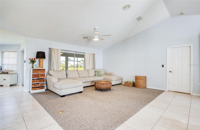 living area with light tile patterned floors, ceiling fan, light colored carpet, baseboards, and high vaulted ceiling