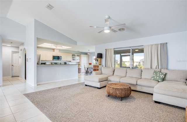 living room with light tile patterned floors, ceiling fan, baseboards, and high vaulted ceiling