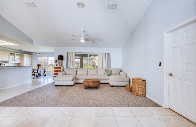 living area featuring light carpet, ceiling fan, vaulted ceiling, light tile patterned floors, and baseboards