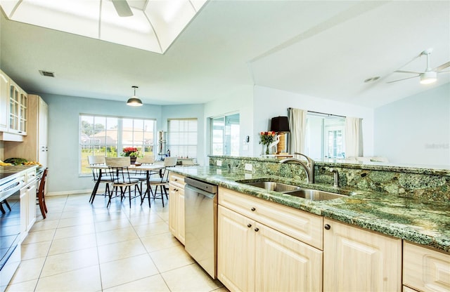 kitchen featuring stainless steel dishwasher, a ceiling fan, a sink, and stone countertops