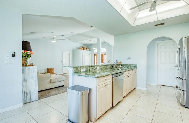 kitchen with stainless steel appliances, ceiling fan, open floor plan, arched walkways, and lofted ceiling