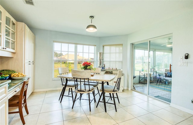 dining area featuring healthy amount of natural light, light tile patterned floors, baseboards, and a ceiling fan