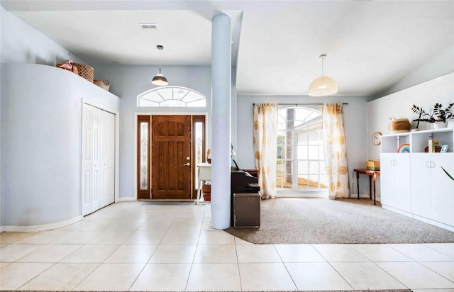 tiled foyer featuring lofted ceiling, healthy amount of natural light, and baseboards
