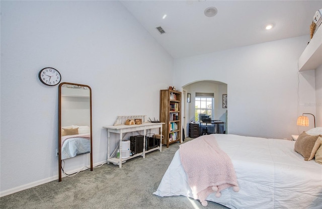 carpeted bedroom with arched walkways, high vaulted ceiling, and baseboards