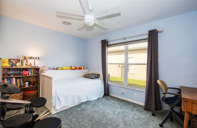 carpeted bedroom with baseboards, a desk, and ceiling fan