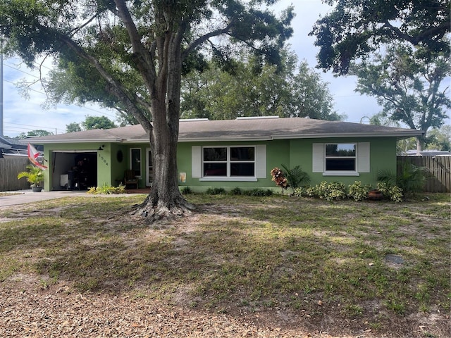 ranch-style house with fence, an attached garage, driveway, and roof with shingles