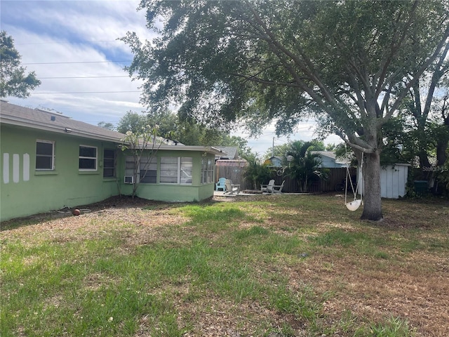 view of yard with an outdoor structure, fence, and a storage shed