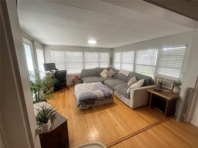 living area with cooling unit and light wood-style flooring