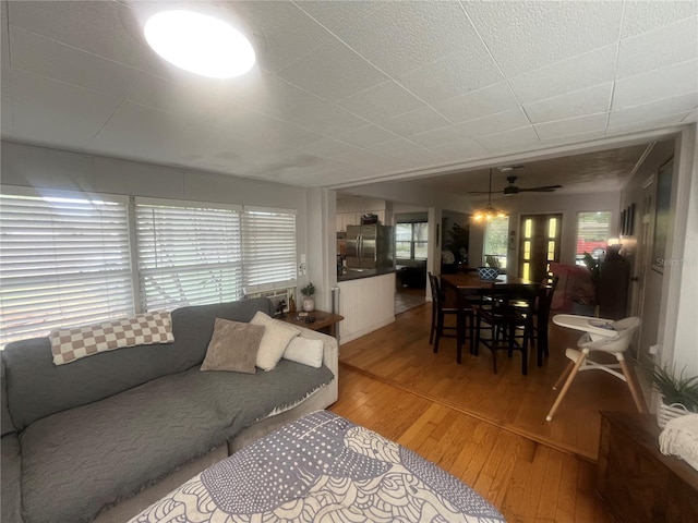 living room with a ceiling fan and light wood finished floors