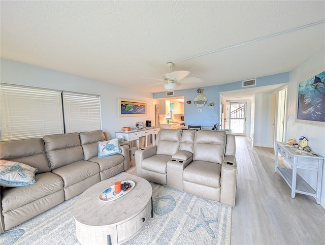 3100 Ocean Shore Blvd Unit 101, Ormond Beach, FL 32176 - living area with light wood finished floors, ceiling fan, and a textured ceiling