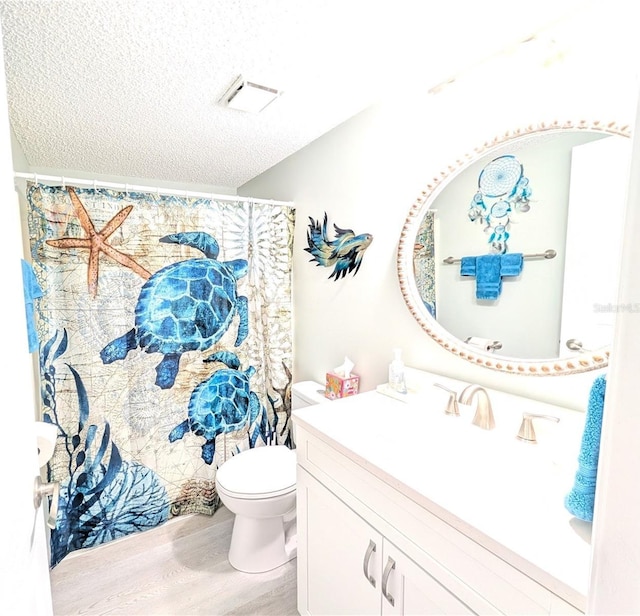 3100 Ocean Shore Blvd Unit 101, Ormond Beach, FL 32176 - full bathroom featuring wood finished floors, vanity, toilet, and a textured ceiling