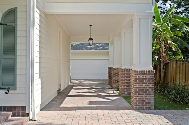 view of patio / terrace featuring decorative driveway, a garage, and covered porch