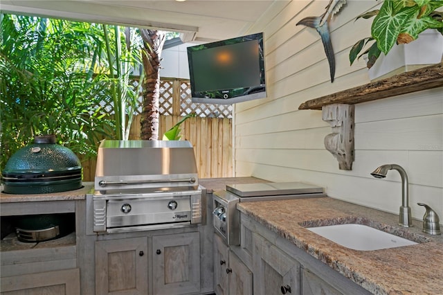 view of patio / terrace with a sink, grilling area, exterior kitchen, and fence