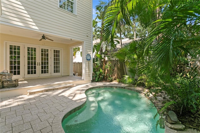 swimming pool with french doors, a patio, ceiling fan, and fence