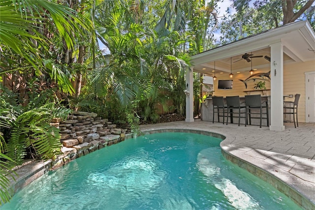 outdoor pool with a patio and ceiling fan