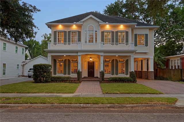 view of front of home with covered porch, a balcony, and driveway