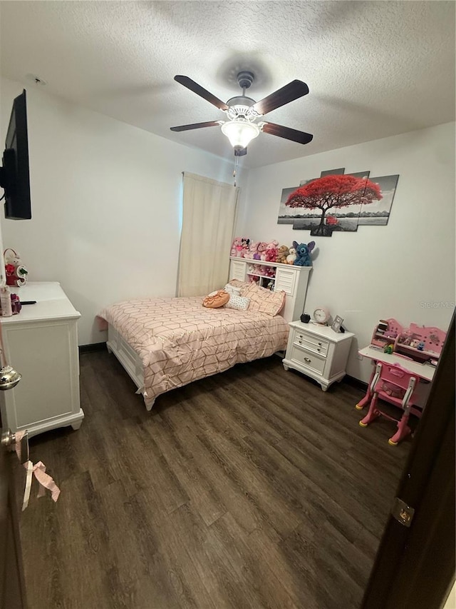 bedroom with ceiling fan, dark wood-style floors, and a textured ceiling