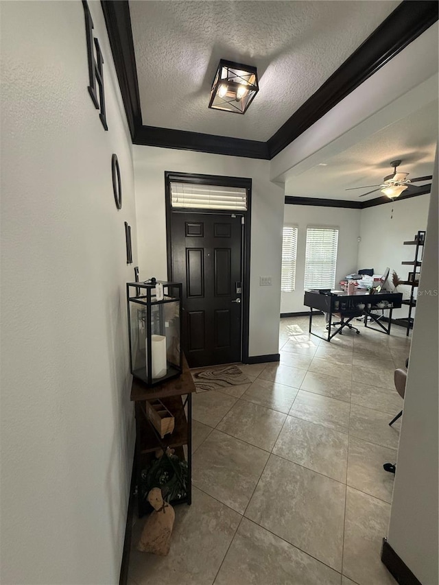 entrance foyer with crown molding, baseboards, a textured ceiling, tile patterned floors, and a ceiling fan
