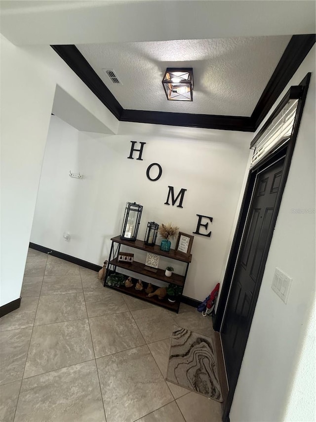 hall featuring ornamental molding, a textured ceiling, and visible vents