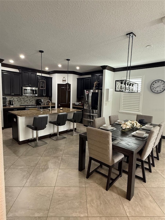dining area with a textured ceiling, crown molding, light tile patterned floors, a chandelier, and recessed lighting