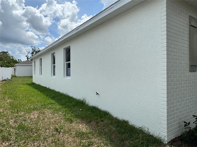 view of property exterior featuring stucco siding and a lawn