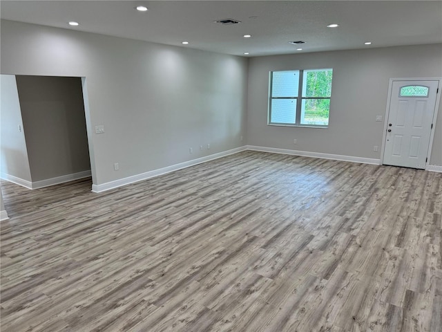 unfurnished living room featuring baseboards, recessed lighting, visible vents, and wood finished floors