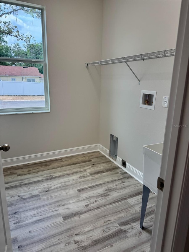 laundry room with baseboards, hookup for an electric dryer, laundry area, and wood finished floors