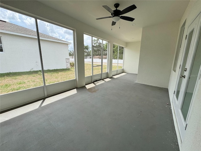 unfurnished sunroom with ceiling fan