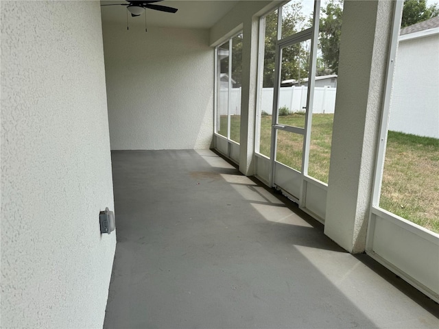 unfurnished sunroom featuring plenty of natural light and a ceiling fan